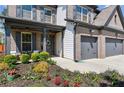 Charming home exterior with well-kept landscaping, a welcoming porch, and a spacious two-car garage at 6435 Privet Way, Cumming, GA 30028