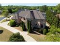 Aerial view of brick house featuring turret, mature landscaping, and backyard pool at 8710 Merion Dr, Duluth, GA 30097