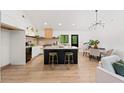 Bright open kitchen featuring a large island with seating, modern lighting, and stainless appliances at 1675 Avon Sw Ave, Atlanta, GA 30311
