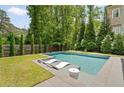 Backyard pool features a tanning ledge, lounge chairs, and well-maintained lawn with privacy fence at 3091 Rhodenhaven Nw Dr, Atlanta, GA 30327