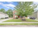 Traditional two-story brick home with manicured lawn, mature tree, and inviting curb appeal at 433 Orchid Ln, Canton, GA 30114