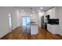 Bright kitchen features wooden floors, an island, stainless steel appliances, and white cabinets at 1092 Hillcrest Se Dr, Atlanta, GA 30316