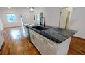 Kitchen island featuring granite countertop with stainless steel sink and white cabinets at 1092 Hillcrest Se Dr, Atlanta, GA 30316