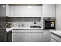 Sleek, white kitchen featuring stainless steel appliances, modern cabinetry, and a subway tile backsplash at 2965 Pharr Court South Nw # 110, Atlanta, GA 30305