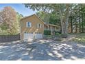 Home featuring a spacious driveway, an attached two-car garage and inviting covered porch with an American flag at 304 N Briar Rdg, Woodstock, GA 30189
