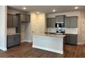 Open kitchen layout with grey cabinets, stainless steel appliances, and granite countertops at 2405 Malster Ln, Lawrenceville, GA 30043