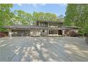 Beautifully landscaped home boasts a contemporary design, an expansive driveway, and mature trees at 1255 Cold Harbor Dr, Roswell, GA 30075