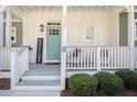 Inviting front porch with rocking chairs, a welcome sign, and a vibrant turquoise door, enhancing curb appeal at 14020 Tributary Ln, Villa Rica, GA 30180