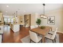 Open-concept kitchen and dining area with hardwood floors and modern lighting fixtures at 3155 Boldmere Se Trl # 3, Smyrna, GA 30080