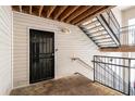 View of a stairwell leading to a unit door, featuring wood flooring, metal railing and painted siding at 3235 Fairington Dr, Lithonia, GA 30038