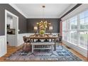Elegant dining room with modern chandelier, stylish decor, large window, and hardwood floors at 100 Coldwater Creek Dr, Mcdonough, GA 30252