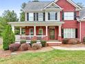 Charming brick home featuring a cozy front porch with white railings and a well-maintained lawn at 100 Coldwater Creek Dr, Mcdonough, GA 30252