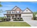 Charming two-story home with a front porch, landscaped yard, and attached two car garage at 881 Springs Crest Dr, Dallas, GA 30157