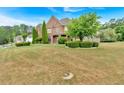 Large brick home with green lawn and trees at 900 Fox Croft Pl, Canton, GA 30114