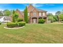 Beautiful landscaped lawn of a brick two-story home on a sunny day at 900 Fox Croft Pl, Canton, GA 30114