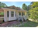 Inviting home featuring a covered front porch, light-colored siding, and mature trees at 2528 Mulberry Rock Rd, Dallas, GA 30157