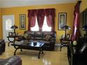 Inviting living room with plush leather furniture, wood floors, and natural light through red-curtained windows at 28 County Line #2 Rd, Rydal, GA 30171