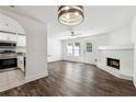 Bright open concept living area with fireplace, hardwood floors, and modern lighting fixtures at 215 Morris Ln, Woodstock, GA 30188