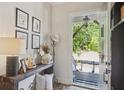 Tastefully decorated entryway with a wooden console table and artwork, leading to a covered front porch at 123 Cricket Ln, Alpharetta, GA 30009