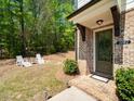Welcoming front porch with brick accents, elegant lighting, and Adirondack chairs nestled in a serene landscape at 3862 Firewood Ln # 110, Suwanee, GA 30024