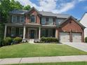 Charming brick home with a welcoming covered front porch, well-maintained landscaping, and an attached two-car garage at 101 Brendylynn Trce, Woodstock, GA 30188