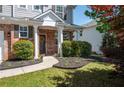 Inviting front porch with brick accents, decorative columns, and lush landscaping leading to the front door at 101 Magnolia Creek Dr, Canton, GA 30115