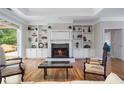 Inviting living room with fireplace, built-in bookshelves, and hardwood floors at 3460 Highgate Hills Ne Dr, Duluth, GA 30097