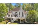 Back of house features balcony with white rails, manicured lawn and mature trees at 4340 Candacraig, Johns Creek, GA 30022