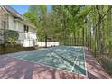 A fenced tennis court is nestled within a lush, green wooded area of the property at 4340 Candacraig, Johns Creek, GA 30022