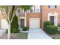 Brick townhouse front door with attached garage and manicured shrubbery at 2324 Towneheights Se Ter # 11, Atlanta, GA 30339