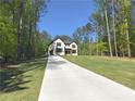Long driveway leading to a two-story modern home surrounded by mature trees on a spacious lot at 191 Darwish Dr, Mcdonough, GA 30252