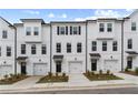 New townhome exterior with white siding, a single car garage, and professionally landscaped front yards at 3145 Washburn Sw St, Atlanta, GA 30354