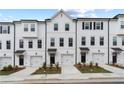 View of townhomes featuring white exterior, black door, driveway, and well-maintained landscaping at 3149 Washburn Sw St, Atlanta, GA 30354