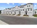 Long shot of new construction townhomes with white exteriors, dark trim, and single car garages at 3149 Washburn Sw St, Atlanta, GA 30354