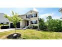 Charming two-story home with a black garage door, neutral siding, and neatly landscaped front yard at 11 Plymouth Ct, Kingston, GA 30145