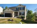 Charming two-story home with a black garage door, neutral siding, and neatly landscaped front yard at 11 Plymouth Ct, Kingston, GA 30145