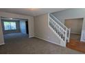 Spacious living room with neutral carpet, fresh paint, and a staircase leading to the upper level at 1395 Kala Dr, Lithonia, GA 30058
