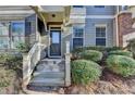 Inviting entryway with well-manicured bushes leading to a stylish townhome entrance at 702 Village Field Ct, Suwanee, GA 30024