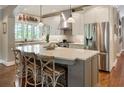 Modern kitchen featuring stainless steel appliances, a large island with seating, and stylish pendant lighting at 1050 Signal Pointe, Alpharetta, GA 30005