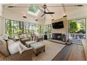 Inviting sunroom featuring a brick fireplace, skylight, comfortable seating, and scenic outdoor views at 1050 Signal Pointe, Alpharetta, GA 30005