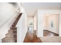 Bright hallway with hardwood floors, a staircase, and an open view into other rooms at 115 Oakwood Dr, Covington, GA 30016
