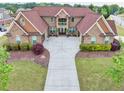 Expansive aerial view of a brick home with meticulous landscaping, a sprawling driveway, and a well-manicured lawn at 401 Sara Ct, Loganville, GA 30052