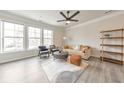 Bright living room featuring large windows, a modern ceiling fan, and stylish furniture creating a cozy atmosphere at 6304 Brookwater Vw, Mableton, GA 30126
