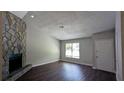 Bright living room with dark wood floors, a stone fireplace, and natural light at 685 Greenhedge Dr, Stone Mountain, GA 30088