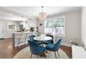 Cozy dining area adjacent to the kitchen, featuring a round table with blue chairs and a modern chandelier at 1659 Beecher Sw St, Atlanta, GA 30310