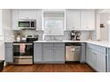 Well-equipped kitchen with gray and white cabinets, stainless steel appliances, and a stylish backsplash at 1659 Beecher Sw St, Atlanta, GA 30310
