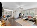 Bright living room featuring hardwood floors, large windows with shutters, a comfortable sofa, and an adjacent dining area at 1659 Beecher Sw St, Atlanta, GA 30310
