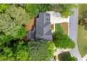 An aerial view of a house with a dark roof surrounded by lush green trees at 11060 Pennbrooke Xing, Johns Creek, GA 30097
