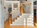 Bright foyer featuring hardwood floors and an elegant staircase with iron spindles at 11060 Pennbrooke Xing, Johns Creek, GA 30097