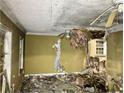 Damaged living room shows ceiling and wall damage with debris on the floor at 1254 Campbellton Sw Rd, Atlanta, GA 30310